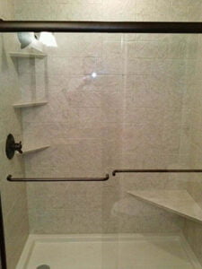 A newly remodeled shower with seating and shelving